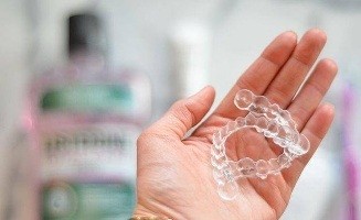 Hand holding two ClearCorrect clear aligners