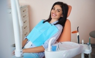Smiling woman sitting patiently in dental chair