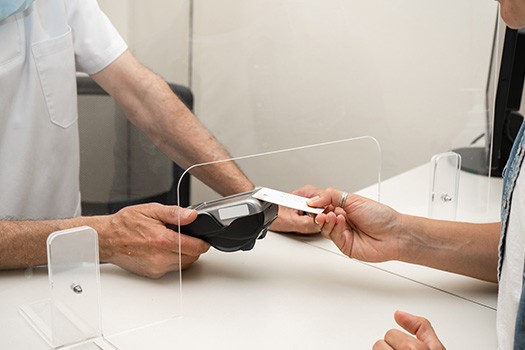 Patient paying dental receptionist with credit card