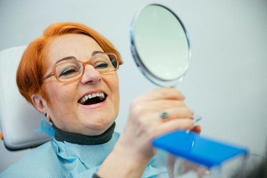 A woman trying on her new dentures