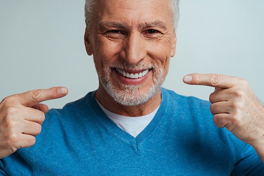 A man smiling with dentures on