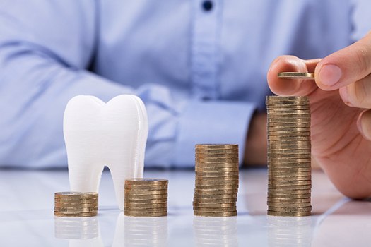 Tooth next to a pile of coins