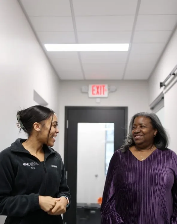 Smiling man hugging smiling woman outdoors on sunny day