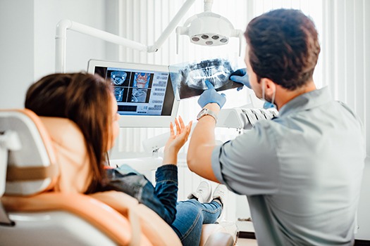 a dentist pointing at an X-ray