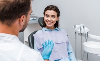 Woman talking to her cosmetic dentist about Invisalign in Edison