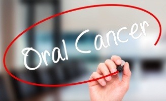 Hand circling the words oral cancer with marker