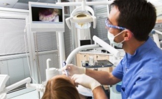 Dentist performing dental exam on a patient using intraoral camera