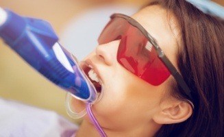 Young woman receiving fluoride varnish in dental office