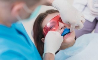 Girl receiving fluoride treatment during preventive dentistry visit