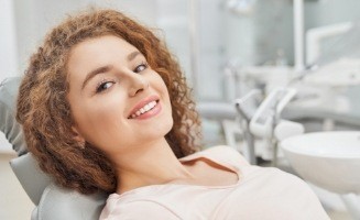 Woman with curly hair leaning back in dental chair