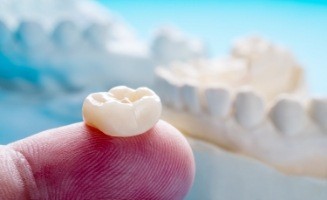 Close up of dental crown on a finger