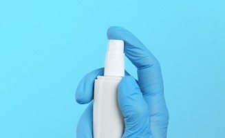 Gloved hand holding a spray bottle