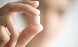 Close up of person holding pill in their hand