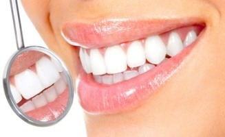 Close up of dental mirror next to smile