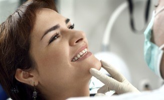 Woman in dental chair smiling at her dentist