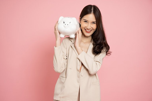 Woman holding a piggy bank over her shoulder and smiling