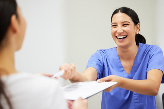 Dentist handing a patient her dental insurance form