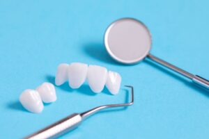Veneers with dental instruments on a blue background
